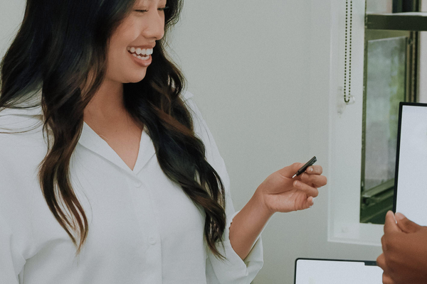 Confident businesswoman smiling while demonstrating YubiKey security device