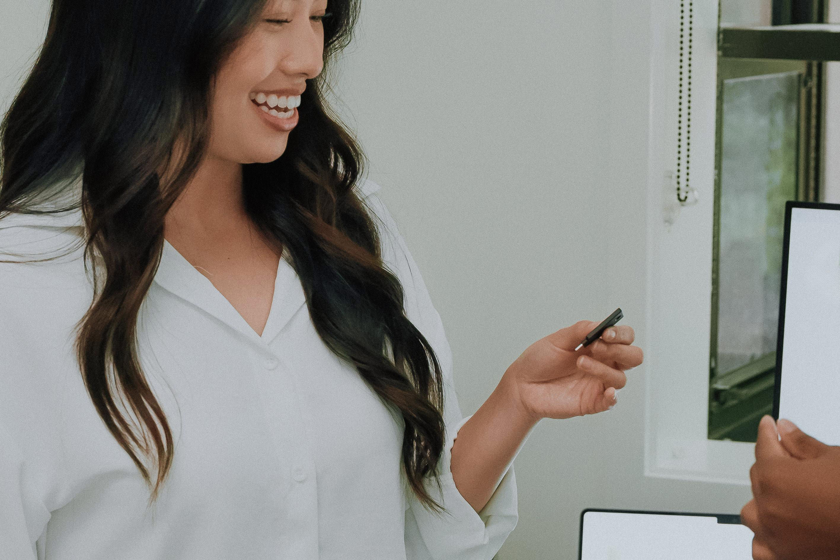 Confident businesswoman smiling while demonstrating YubiKey security device