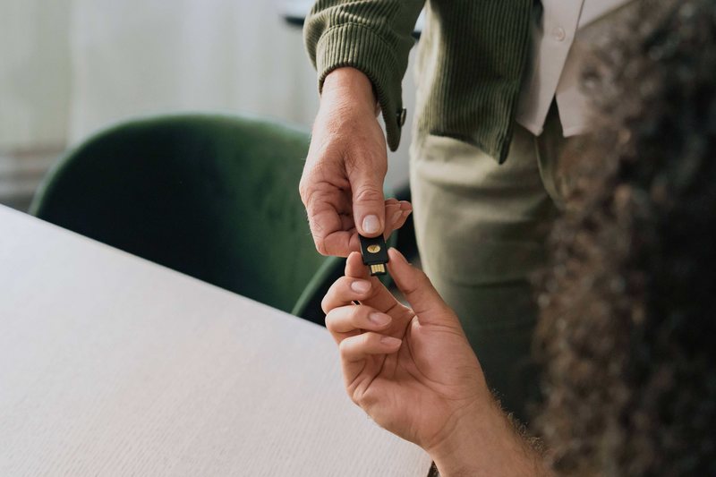 Person using YubiKey NFC authentication on tablet device for secure login