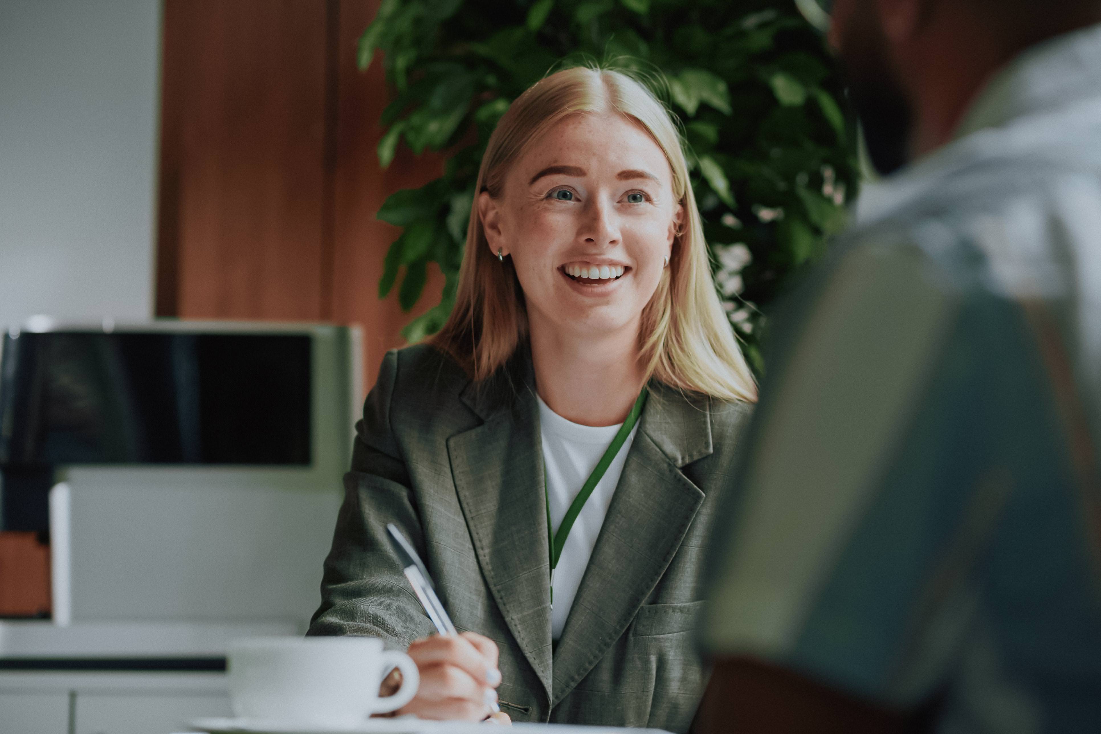 Professional businesswoman smiling confidently in modern office meeting environment